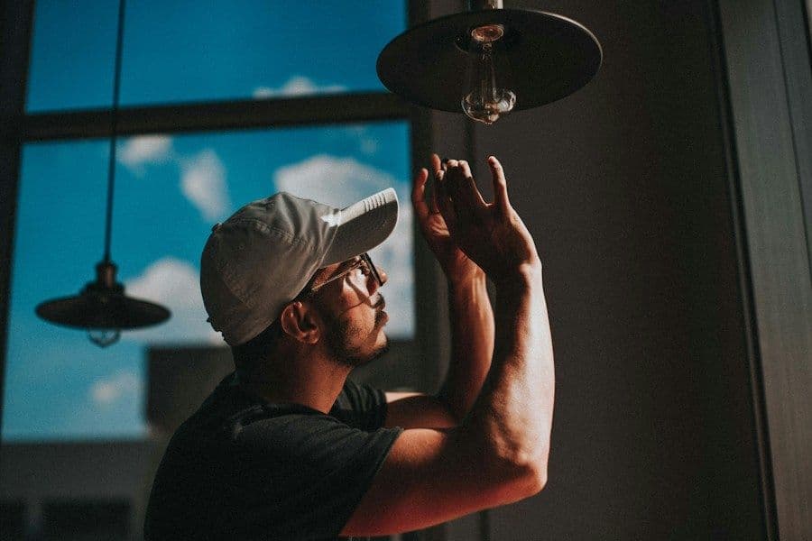 Elektricien monteert een hanglamp aan het plafond